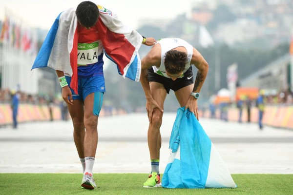 Fraternal apoyo. Derlis Ayala ayuda a Federico Bruno a llegar a la meta en la prueba de maratón.