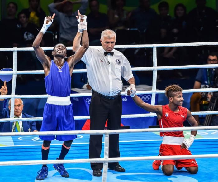 El colombiano Yurbenjen Martínez, de rodillas, celebra su triunfo ante el cubano Joahnys Argilagos, en semifinal de boxeo (49 Kg.)